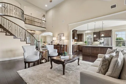 a living room with furniture kitchen view and a wooden floor