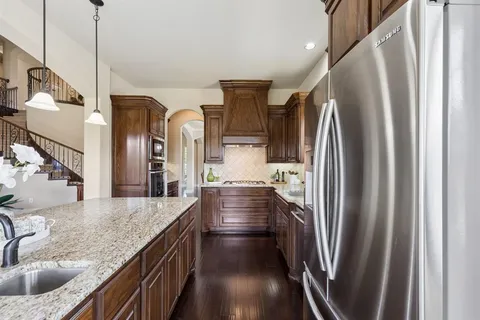 a kitchen with stainless steel appliances granite countertop a refrigerator and a sink
