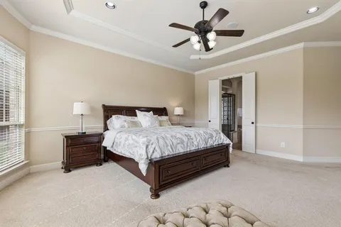 a bedroom with a bed and a ceiling fan
