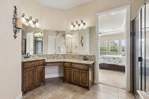 a bathroom with a granite countertop sink a large mirror and a window
