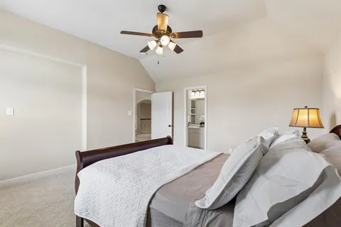 a bedroom with a large bed and chandelier