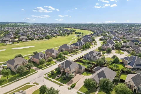 an aerial view of ocean and residential houses with outdoor space