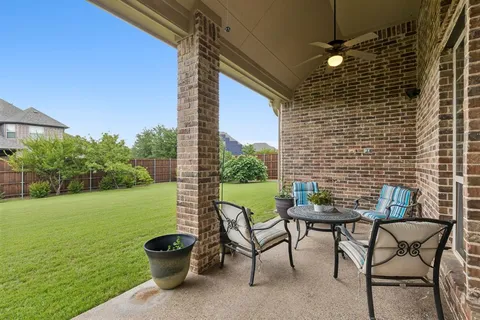 a view of a patio with a table and chairs and potted plants