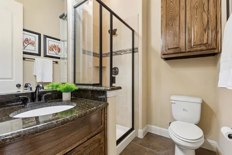 a bathroom with a granite countertop sink a toilet and a mirror