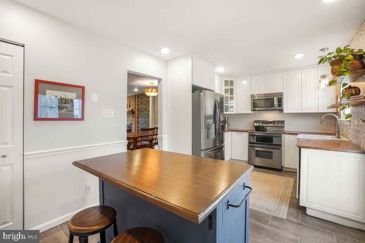 5712 Richardson Mews Square Halethorpe, MD 21227 - Photo 13 of 29 a kitchen with stainless steel appliances granite countertop a sink refrigerator stove and microwave
