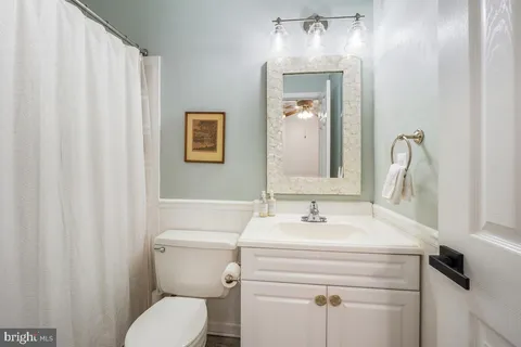 a bathroom with a sink mirror and toilet