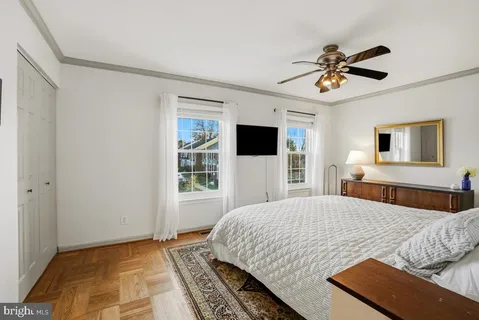 a bedroom with a large bed a flat tv screen and dresser