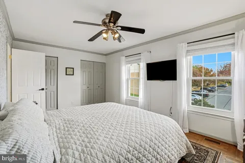 a bedroom with a large bed a flat tv screen and a window