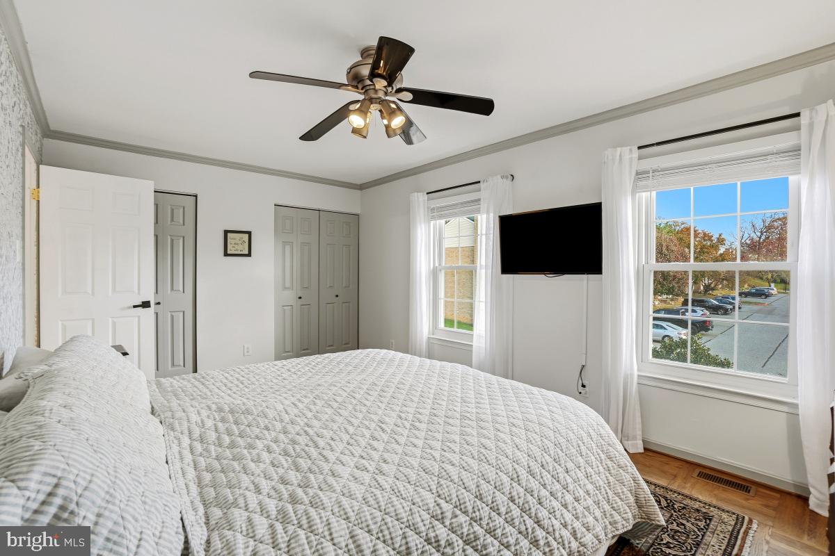 5712 Richardson Mews Square Halethorpe, MD 21227 - Photo 22 of 29 a bedroom with a large bed a flat tv screen and a window