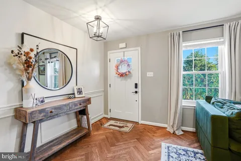 a living room with furniture a mirror and a window