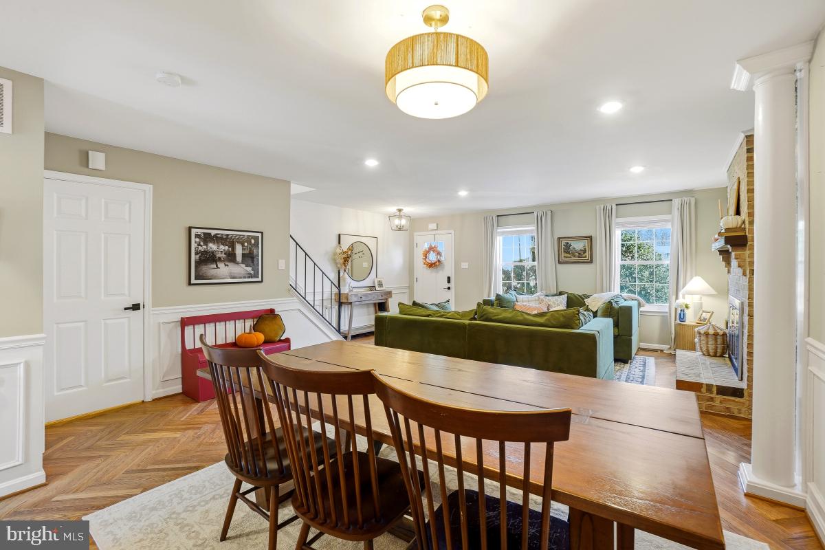 5712 Richardson Mews Square Halethorpe, MD 21227 - Photo 9 of 29 a view of a dining room and livingroom with furniture wooden floor a rug a flat screen tv a painting and a chandelier