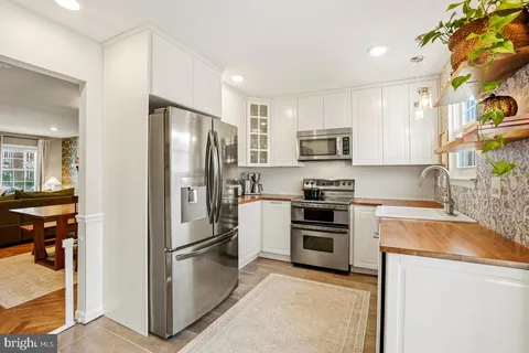 a kitchen with stainless steel appliances granite countertop a refrigerator stove and sink
