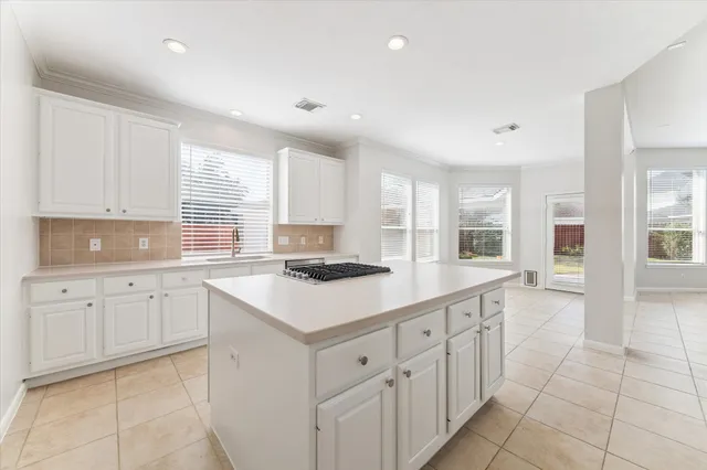a kitchen with cabinets appliances a sink and a window