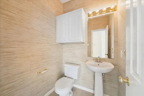 a bathroom with a sink toilet and mirror