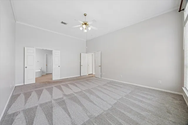 a view of an empty room with a chandelier fan