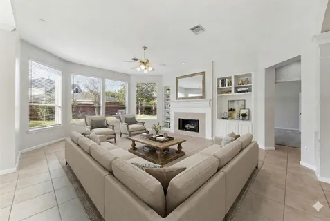 a living room with furniture fireplace and a large window