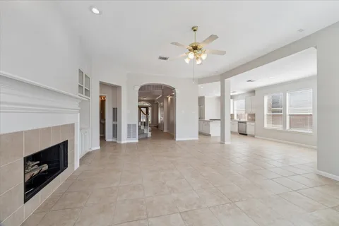 a view of an empty room with a fireplace and a window