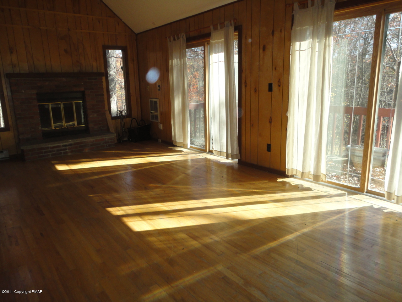 211 Decker Road Bushkill, PA 18324 - Photo 2 of 5 a view of a livingroom with wooden floor and a fireplace