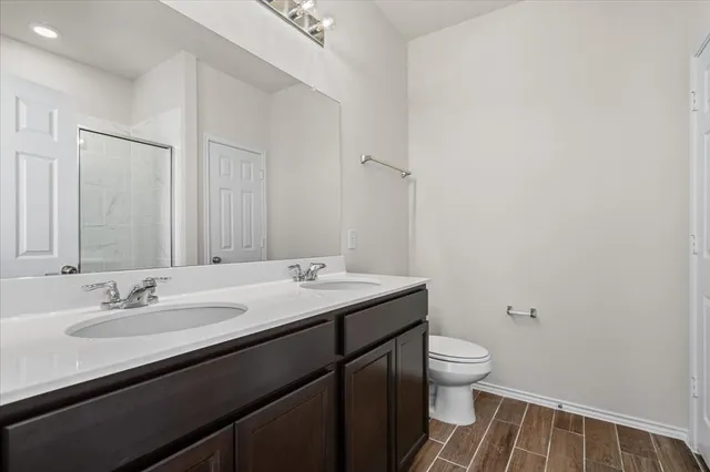 a bathroom with a sink a toilet and a mirror