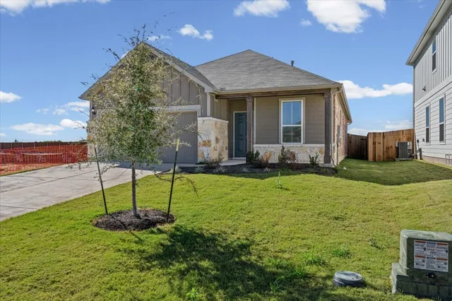 a view of a house with backyard and sitting area