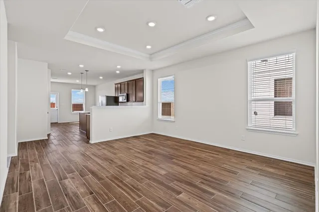 a view of a big room with wooden floor and windows