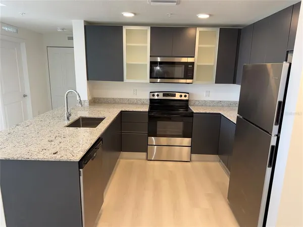 a kitchen with kitchen island a refrigerator sink and stove