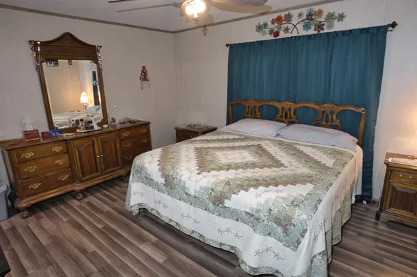 a bedroom with a bed and a mirror on dresser