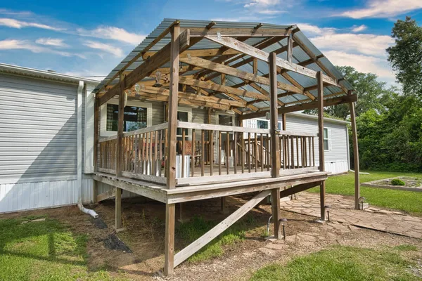 a view of a house with a wooden deck and a yard