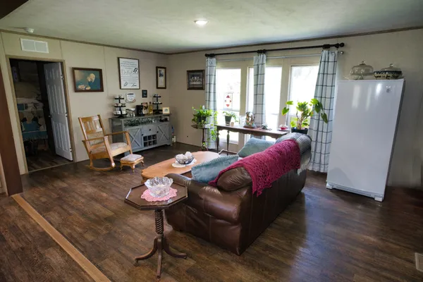 a living room with furniture a wooden floor and a large window