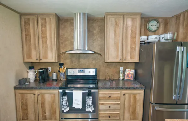 a kitchen with stainless steel appliances granite countertop a refrigerator and a stove top oven