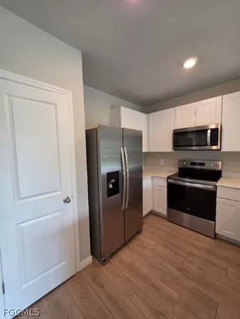 a kitchen with granite countertop a refrigerator and a stove top oven