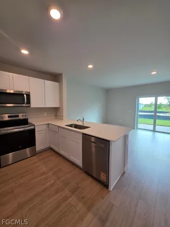 a large kitchen with stainless steel appliances granite countertop a stove a sink and a microwave