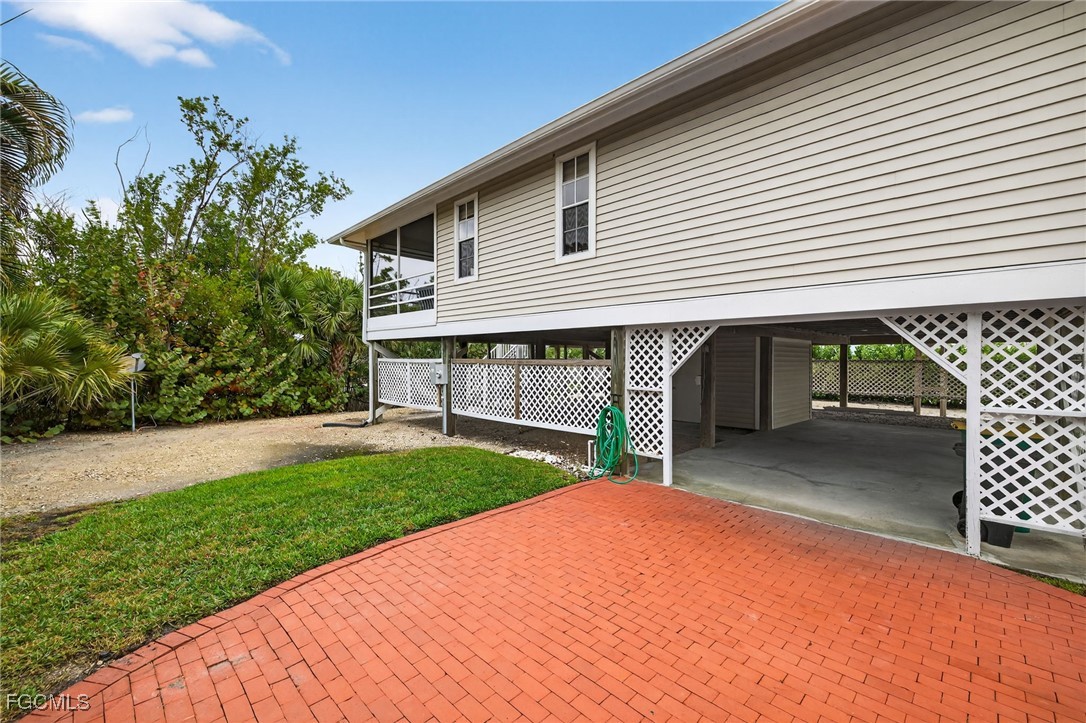 966 Sand Castle Road Sanibel, FL 33957 - Photo 28 of 39 a front view of a house with a yard and garage