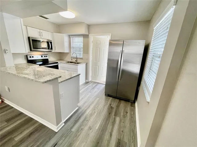 a kitchen with granite countertop a sink and steel appliances