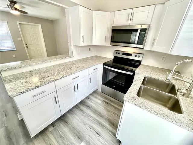 a view of a refrigerator in kitchen and wooden floor