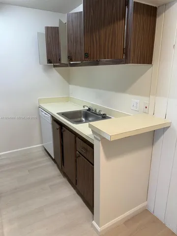 a kitchen with a sink cabinets and a wooden floor