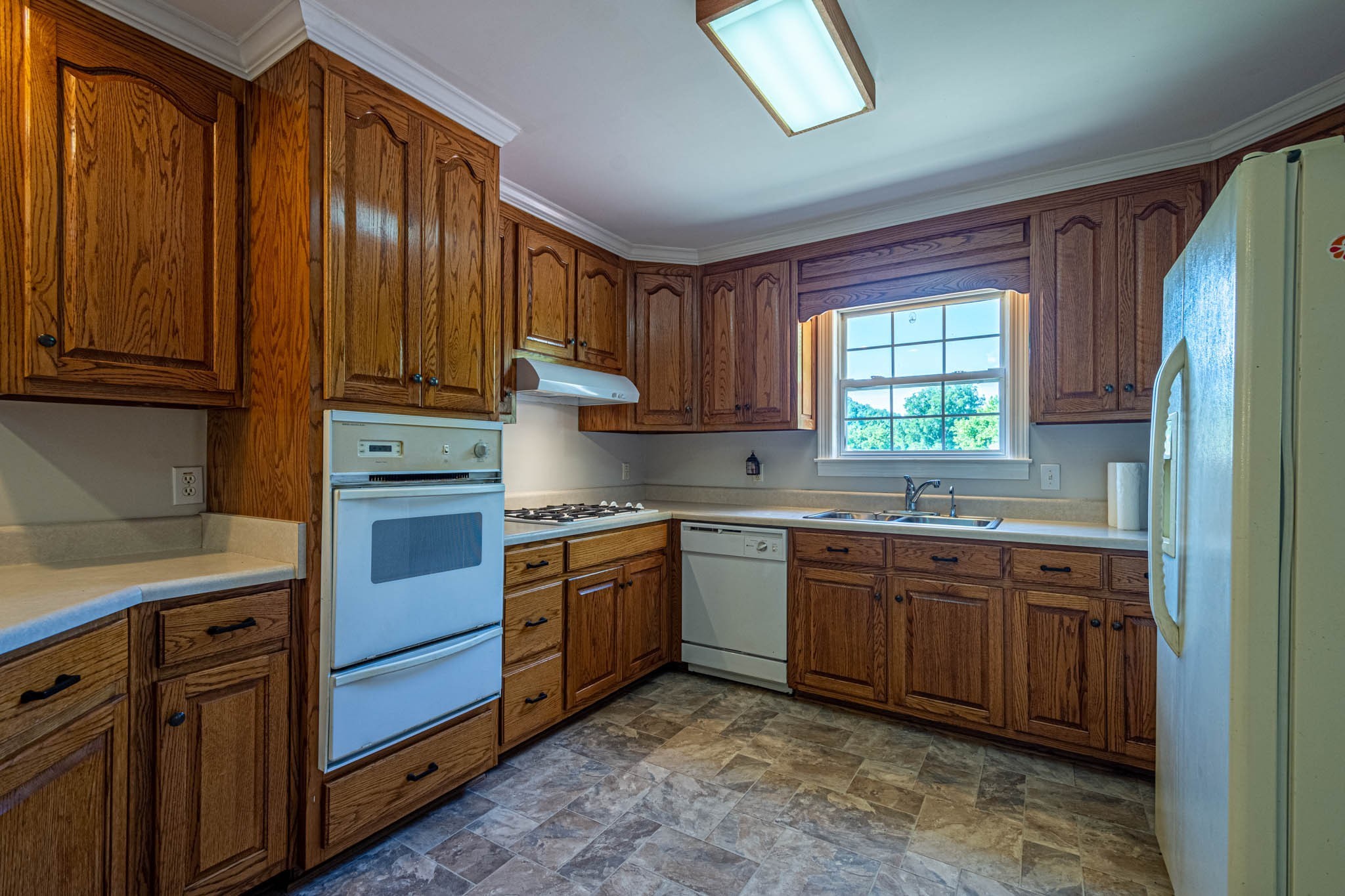 1316 Powdermill Hill Road Lawrenceburg, TN 38464 - Photo 16 of 70 a kitchen with stainless steel appliances granite countertop wooden cabinets a sink and a window