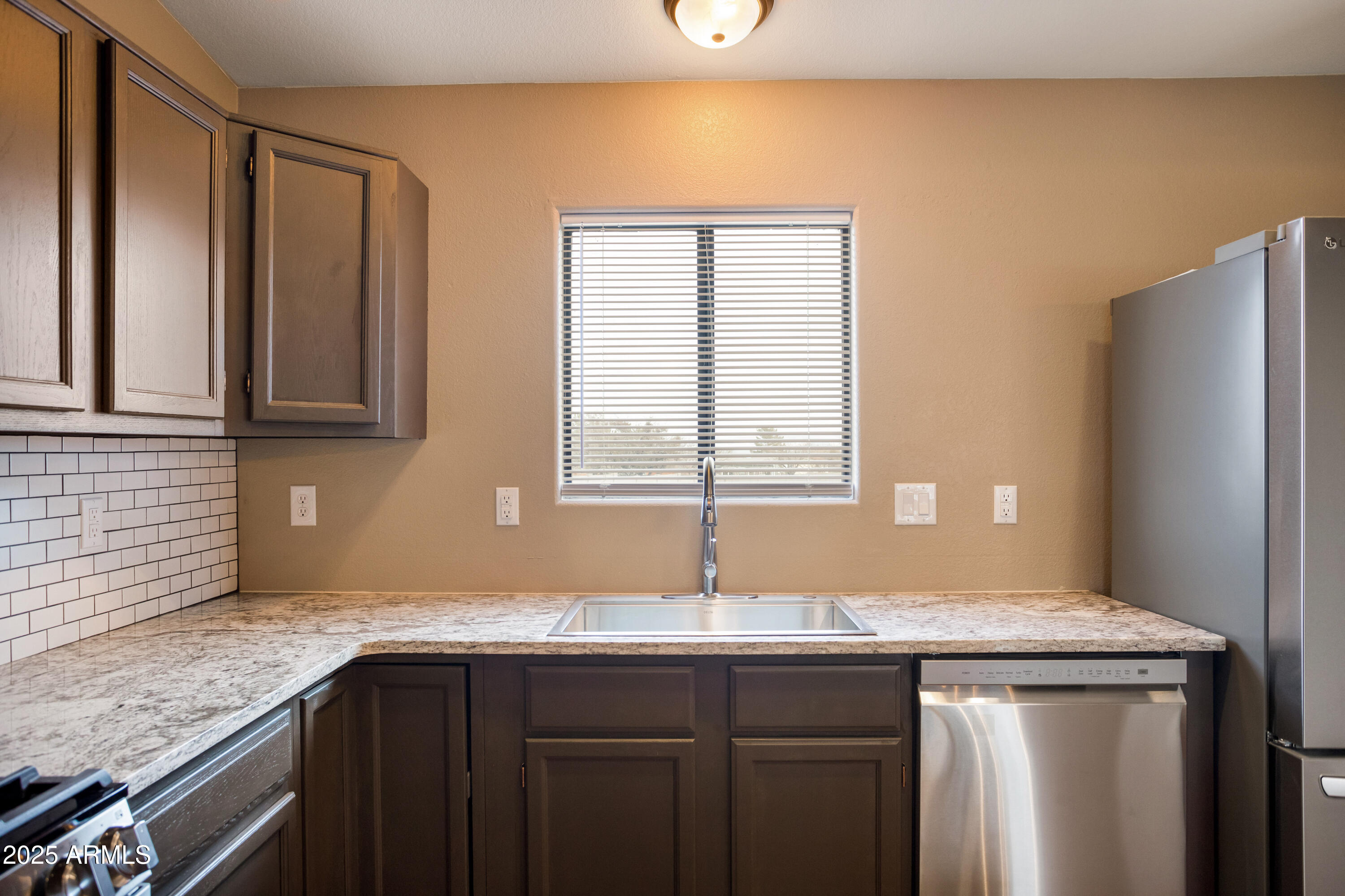 5837 South Wild Rose Road Hereford, AZ 85615 - Photo 14 of 46 a kitchen with stainless steel appliances granite countertop a sink and a wooden cabinets