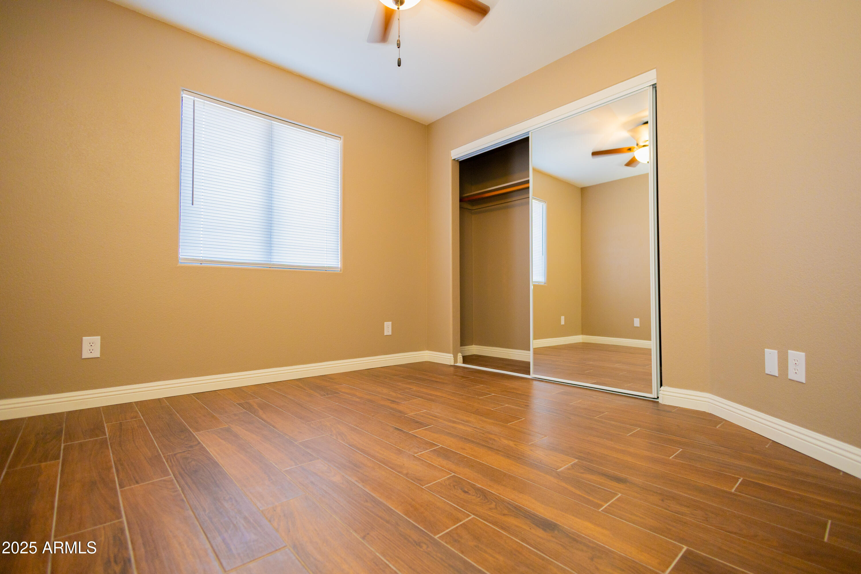 5837 South Wild Rose Road Hereford, AZ 85615 - Photo 20 of 46 an empty room with wooden floor and a ceiling fan