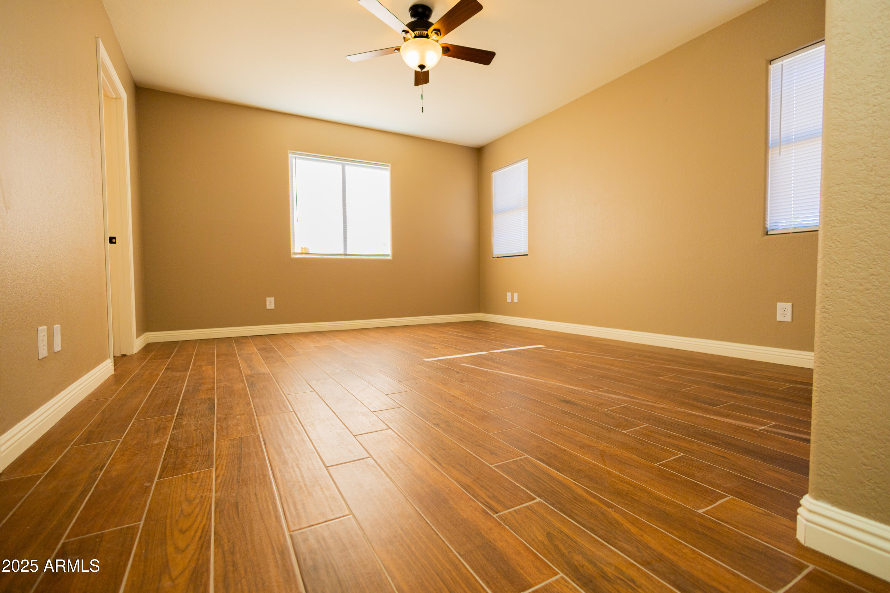 5837 South Wild Rose Road Hereford, AZ 85615 - Photo 27 of 46 a view of an empty room with wooden floor and a window