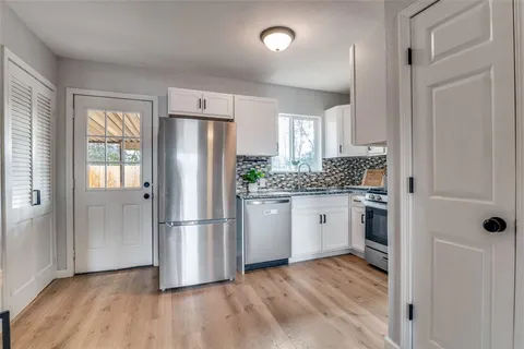 a kitchen with a refrigerator wooden floor and window