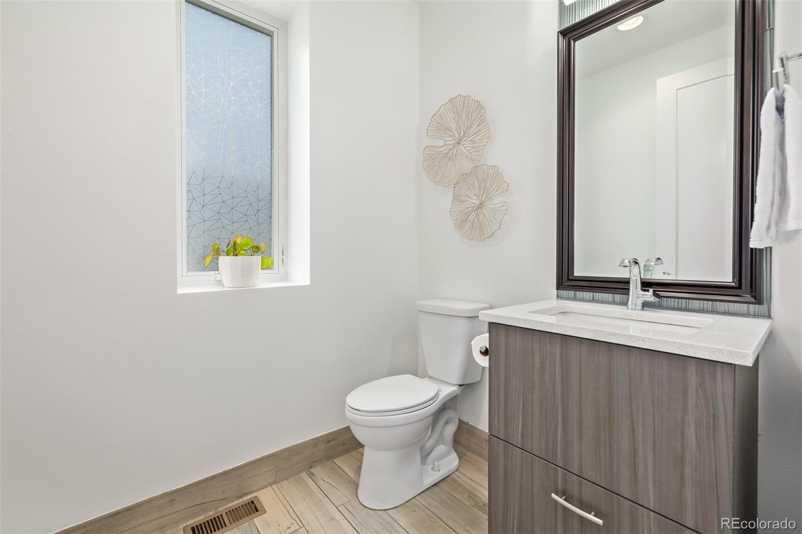2245 Meade Street Denver, CO 80211 - Photo 14 of 40 a bathroom with a toilet sink and mirror