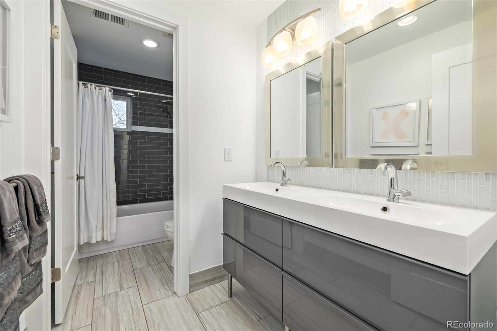 2245 Meade Street Denver, CO 80211 - Photo 24 of 40 a bathroom with a double vanity sink a mirror and a bathtub
