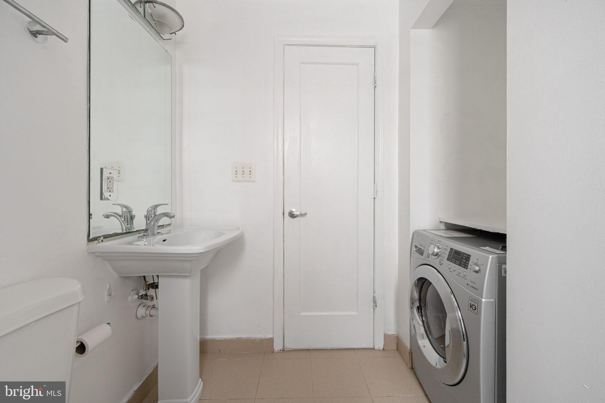 1314 Massachusetts Avenue Northwest, Unit 608 Washington, DC 20005 - Photo 20 of 40 a bathroom with a sink a washer and dryer