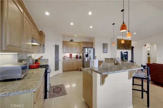 a large kitchen with kitchen island a sink stainless steel appliances and a fireplace