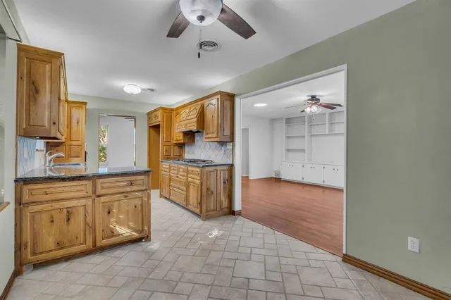 a large kitchen with stainless steel appliances a refrigerator and a stove top oven