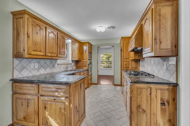 a kitchen with granite countertop cabinets and window