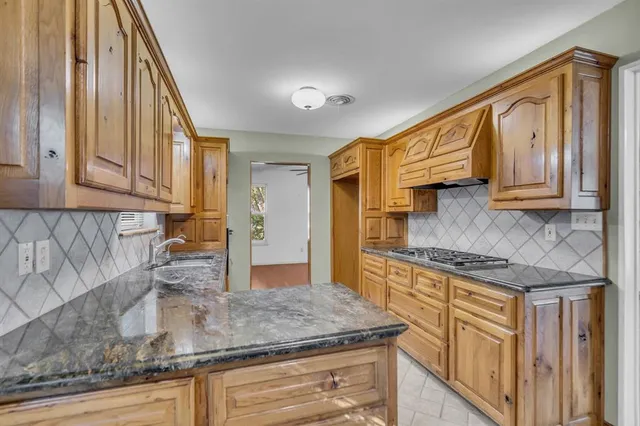 a kitchen with stainless steel appliances granite countertop a sink and cabinets