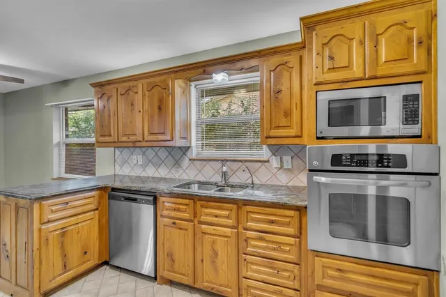 a kitchen with stainless steel appliances granite countertop a stove microwave and cabinets
