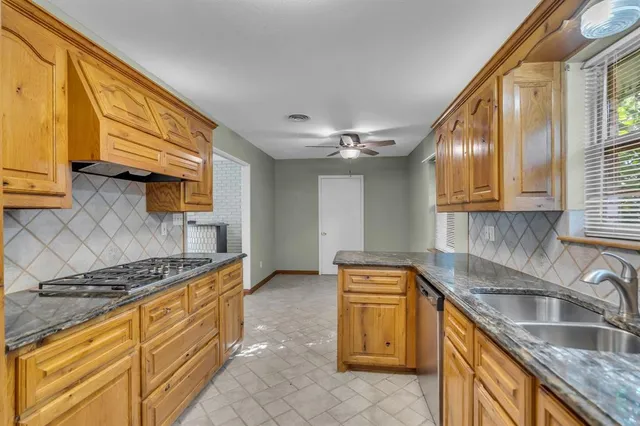 a kitchen with stainless steel appliances granite countertop a sink stove and cabinets